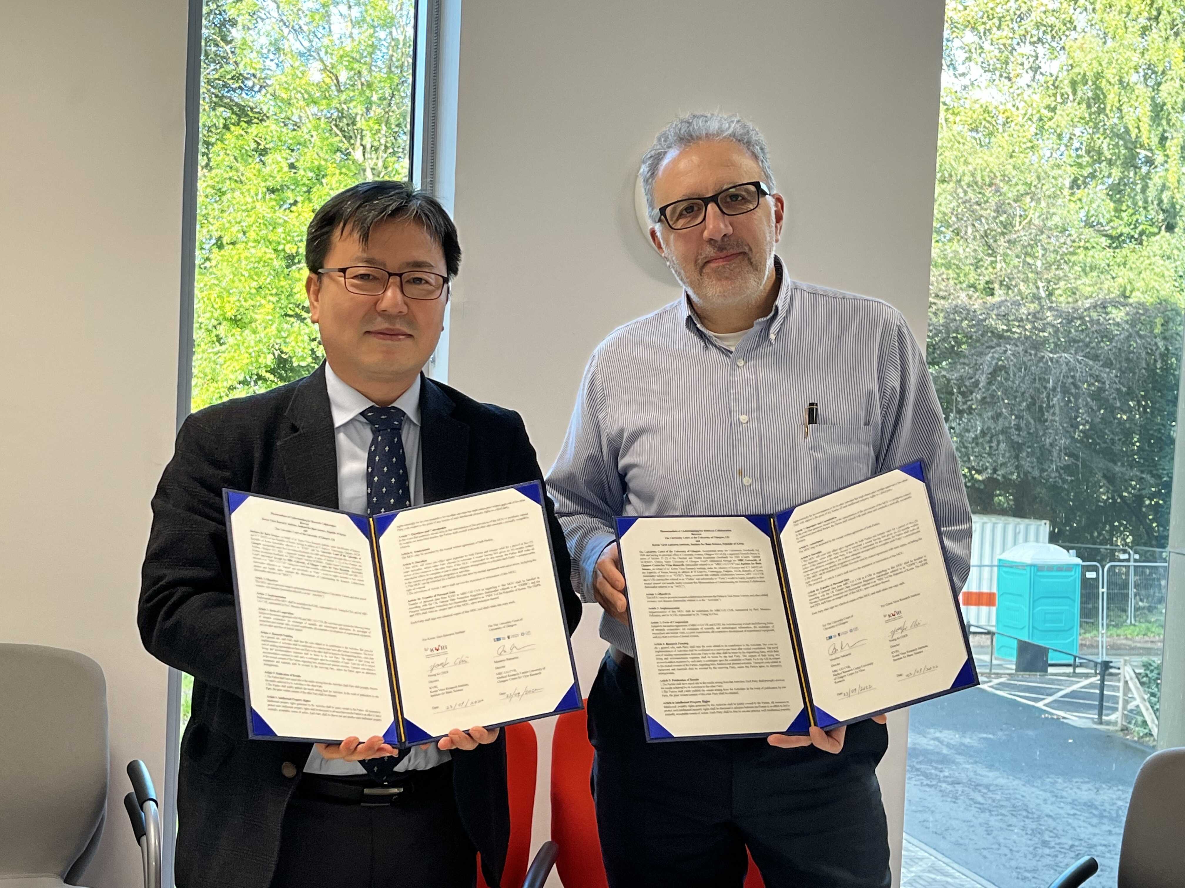 최영기 IBS 한국바이러스기초연구소 소장(왼쪽)과 마시모 팔마리니 영국 MRC 바이러스연구센터 소장이 업무협약 체결 후 기념사진을 촬영하고 있다.