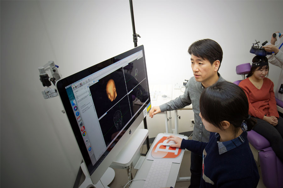 경두개자기자극술로 활성화된 뇌 영역을 확인 중인 김성신 교수. 경두개자기자극술은 비침습적 뇌작극 기술로, 전류가 흐르는 코일로부터 유도된 자기장을 이용해 신경신호를 유도한다.