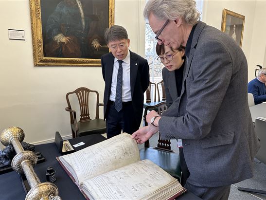 IBS President NOH Do Young (left), Director KIM V. Narry (center), chief librarian of the Royal Society (right) are viewing the charter containing signatures of all Royal Society members